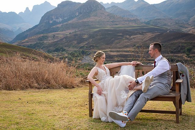 Bride and groom on a bench with the Drakensberg in the background